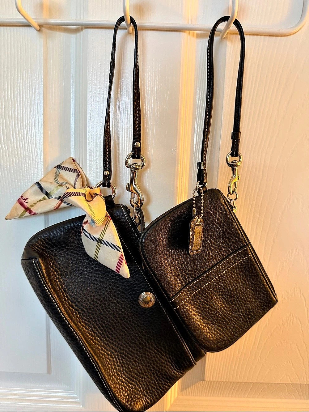 Coach black pebbled leather wristlets adorned with a plaid scarf detail